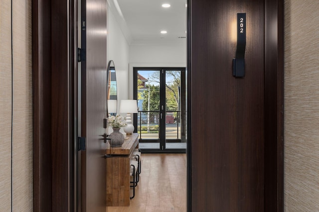 hall featuring recessed lighting, wood finished floors, and ornamental molding