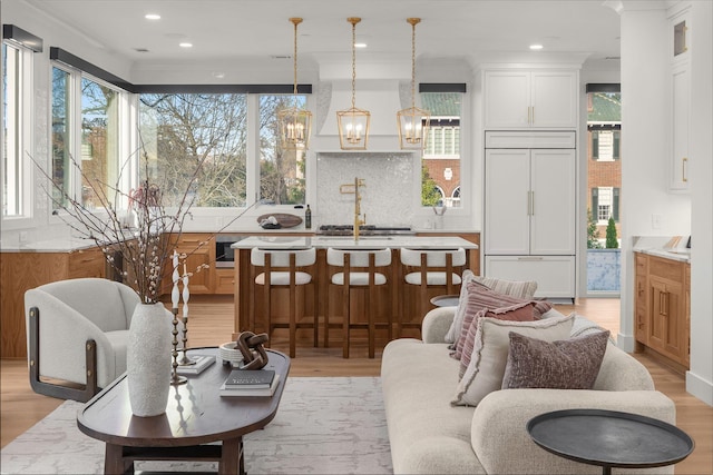 living area with light wood-type flooring, recessed lighting, and a notable chandelier