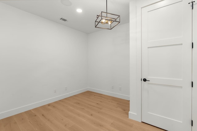 unfurnished room featuring recessed lighting, light wood-type flooring, baseboards, visible vents, and a notable chandelier