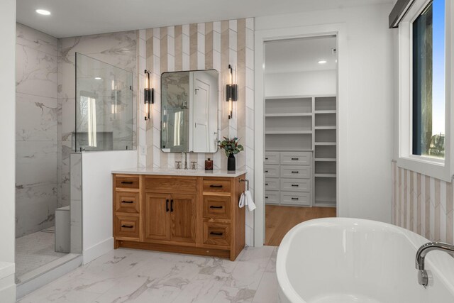 bathroom featuring vanity, a soaking tub, recessed lighting, and a marble finish shower