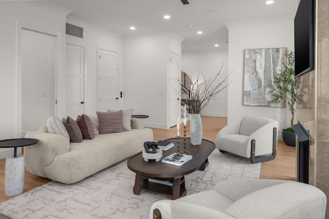 living room featuring baseboards, recessed lighting, ornamental molding, and wood finished floors