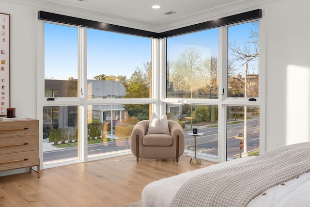 bedroom with visible vents, multiple windows, and wood finished floors