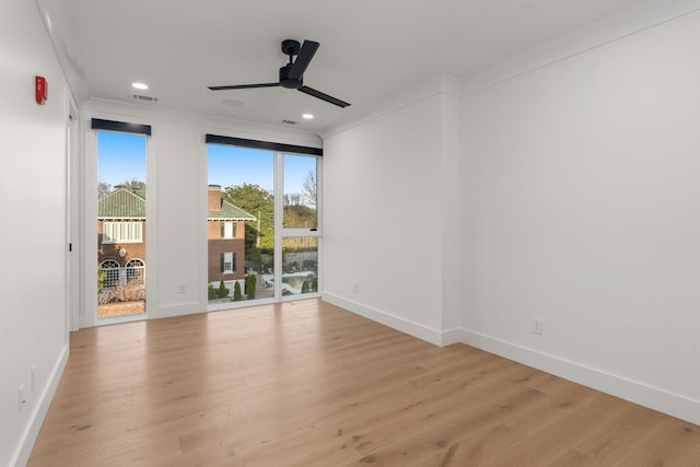 spare room with light wood-style flooring, ceiling fan, ornamental molding, and baseboards