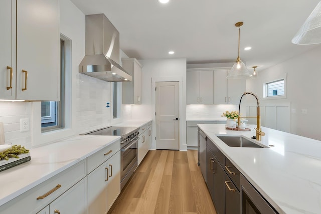 620 Waco Dr Unit B, Nashville, TN 37209 - kitchen featuring tasteful backsplash, stainless steel appliances, a sink, pendant lighting, and wall chimney exhaust hood