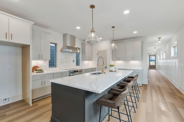 620 Waco Dr Unit B, Nashville, TN 37209 - kitchen with wall chimney range hood, a sink, light wood-style floors, visible vents, and a center island with sink