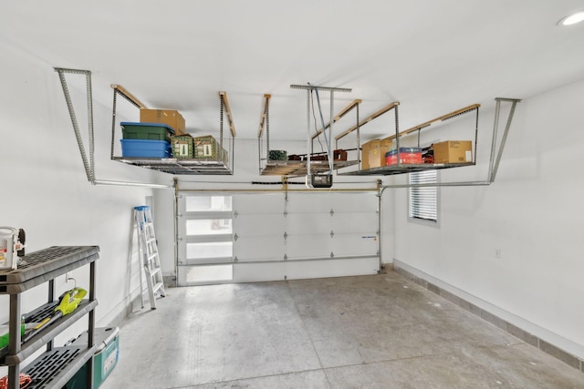 garage with a garage door opener and baseboards