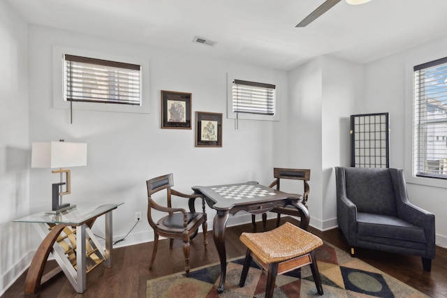 office space with wood finished floors, visible vents, a ceiling fan, and baseboards