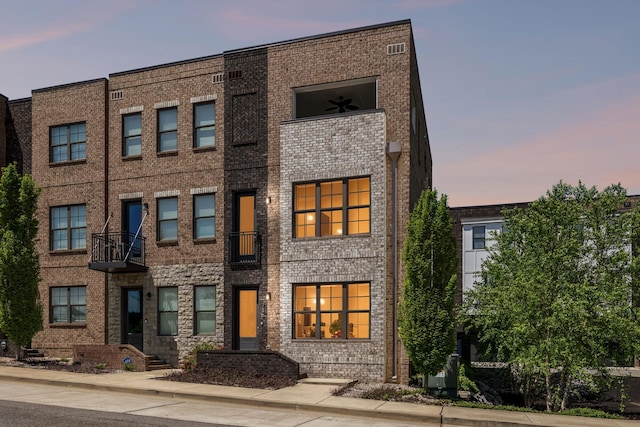 multi unit property with brick siding and a balcony