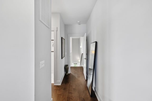 corridor featuring dark wood finished floors and visible vents