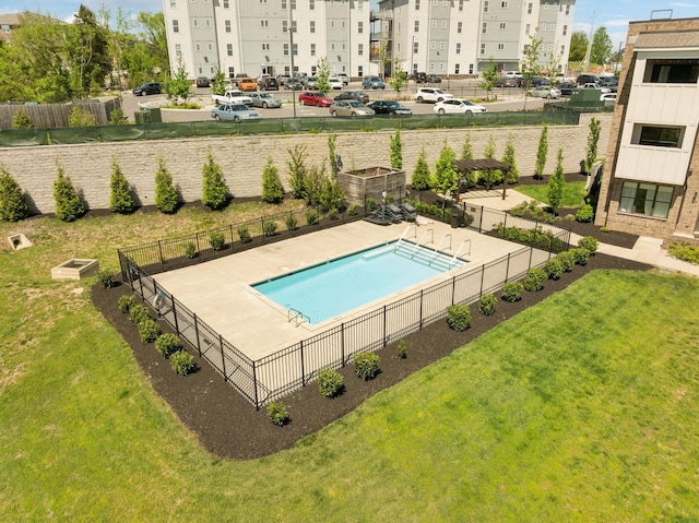 community pool featuring fence and a yard