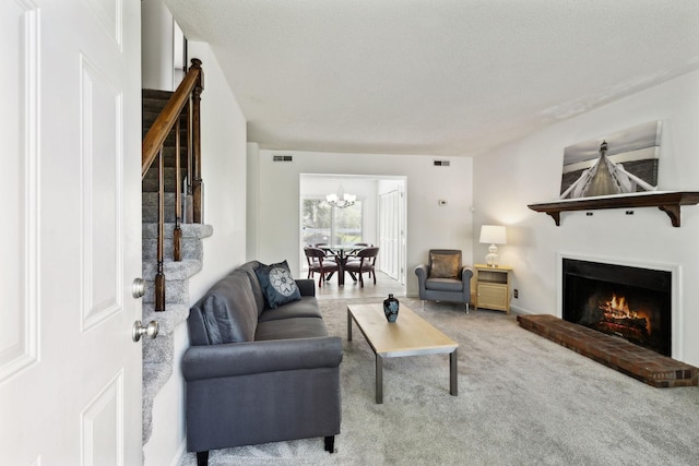 carpeted living room with visible vents, a notable chandelier, stairway, and a fireplace