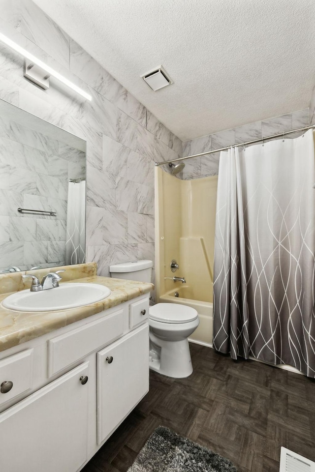 full bathroom featuring vanity, a textured ceiling, and visible vents