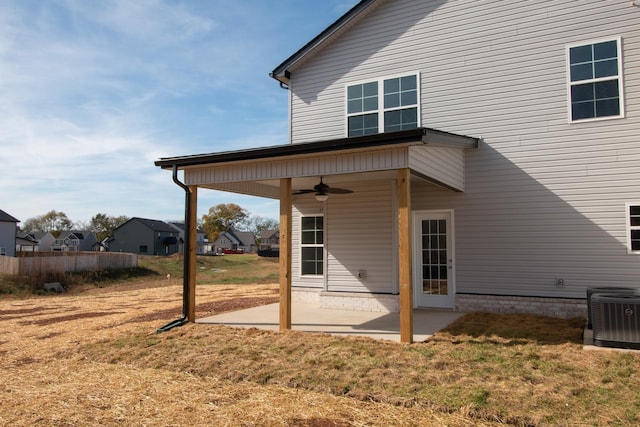 back of property with ceiling fan, a patio area, central air condition unit, a yard, and a residential view