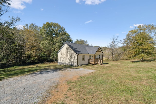 exterior space featuring a lawn, driveway, and a wooden deck