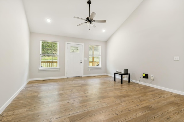 interior space with ceiling fan, baseboards, light wood-style flooring, and a healthy amount of sunlight