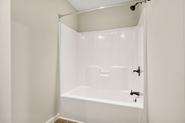 full bathroom featuring wood finished floors and washtub / shower combination
