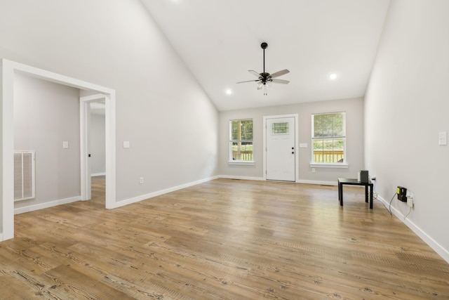 unfurnished living room featuring light wood-style floors, ceiling fan, high vaulted ceiling, visible vents, and baseboards