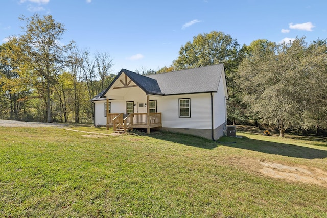 view of front of property with a wooden deck, roof with shingles, crawl space, central AC unit, and a front lawn