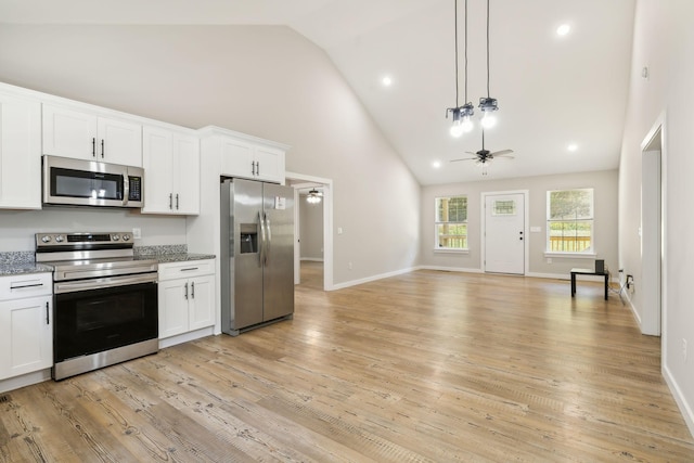 kitchen with stainless steel appliances, high vaulted ceiling, a ceiling fan, white cabinetry, and open floor plan