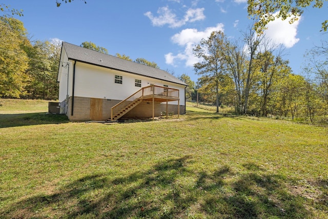 rear view of house featuring a deck, a lawn, and stairs