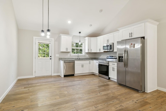 kitchen featuring white cabinetry, light wood-style floors, stainless steel appliances, vaulted ceiling, and hanging light fixtures