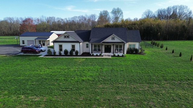 view of front of property with a porch, a front lawn, driveway, and a garage