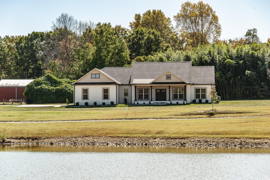 view of front of home featuring a water view and a front lawn