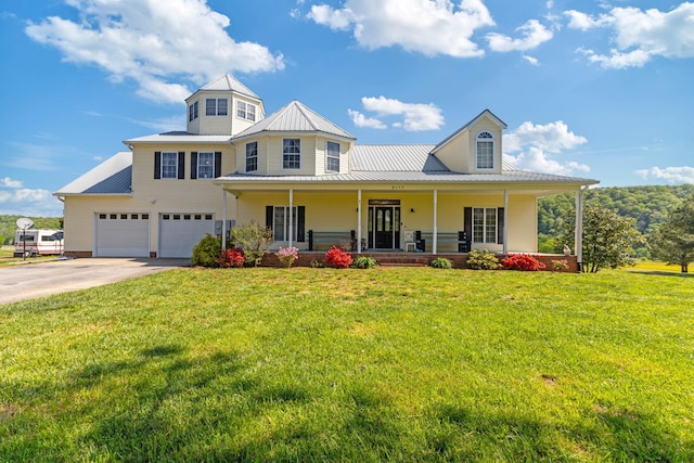 view of front of home featuring covered porch, driveway, metal roof, and an attached garage