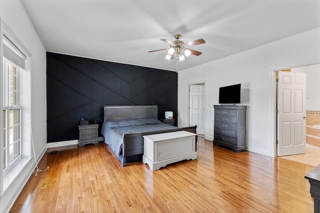 bedroom featuring baseboards, light wood-type flooring, and a ceiling fan