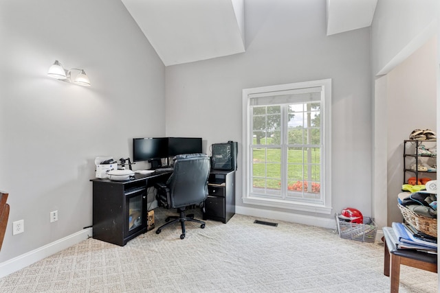 office space featuring visible vents, carpet flooring, lofted ceiling, and baseboards