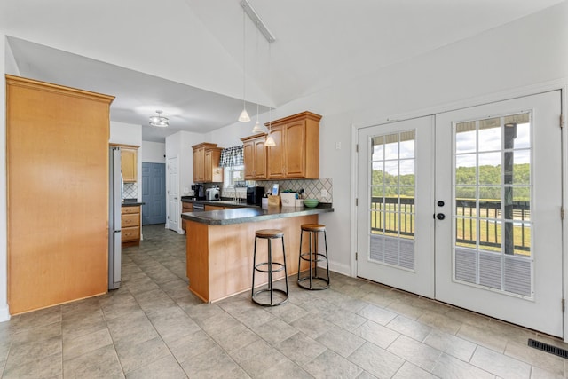 kitchen with a peninsula, french doors, and decorative backsplash