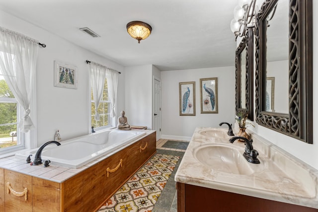 full bath with baseboards, visible vents, a bath, and a sink
