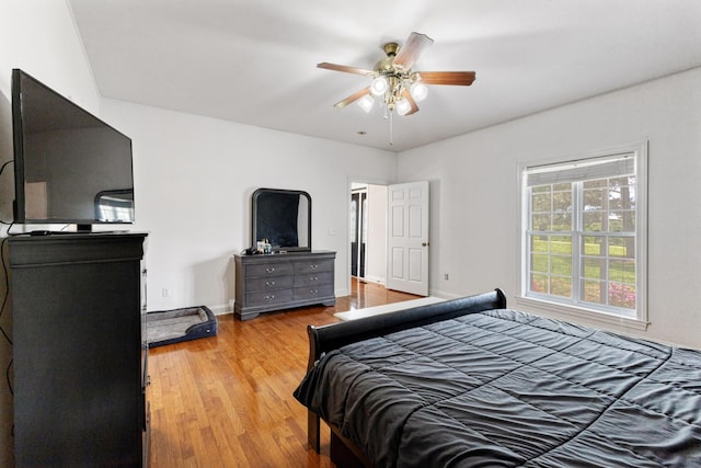 bedroom with wood finished floors, a ceiling fan, and baseboards