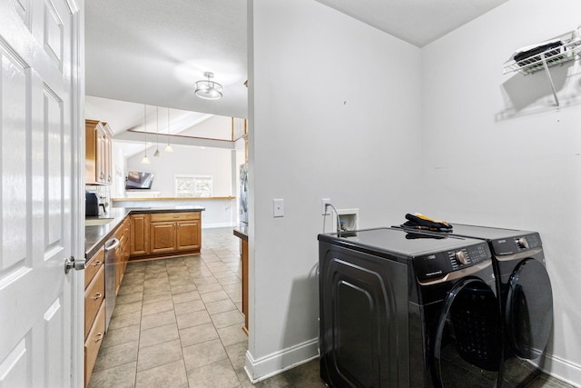 laundry area featuring light tile patterned floors, washer and dryer, laundry area, and baseboards