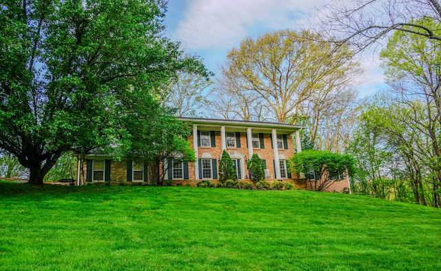 view of front of house featuring brick siding and a front yard