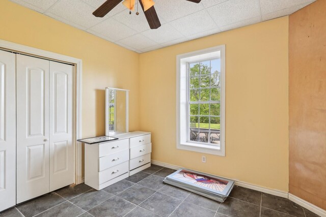 4025 Moore Hollow Rd, Woodlawn, TN 37191 - bedroom featuring baseboards, a closet, a drop ceiling, dark tile patterned flooring, and a ceiling fan
