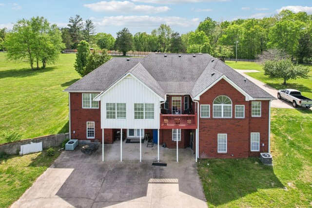 4025 Moore Hollow Rd, Woodlawn, TN 37191 - rear view of property featuring cooling unit, a lawn, board and batten siding, brick siding, and concrete driveway