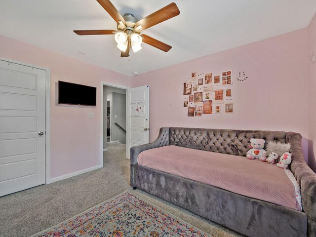 carpeted bedroom featuring baseboards and a ceiling fan