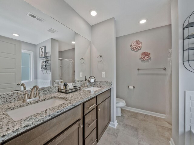 full bath featuring toilet, a sink, baseboards, and visible vents