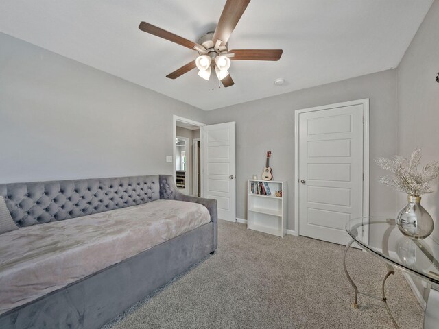 carpeted bedroom with ceiling fan and baseboards