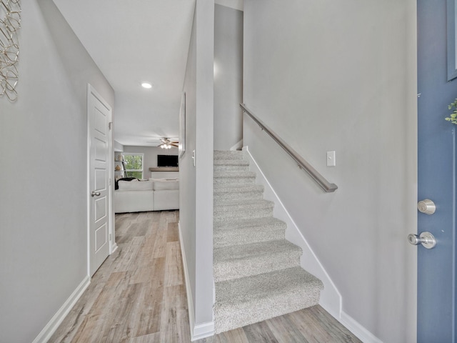 stairway featuring wood finished floors, recessed lighting, a ceiling fan, and baseboards