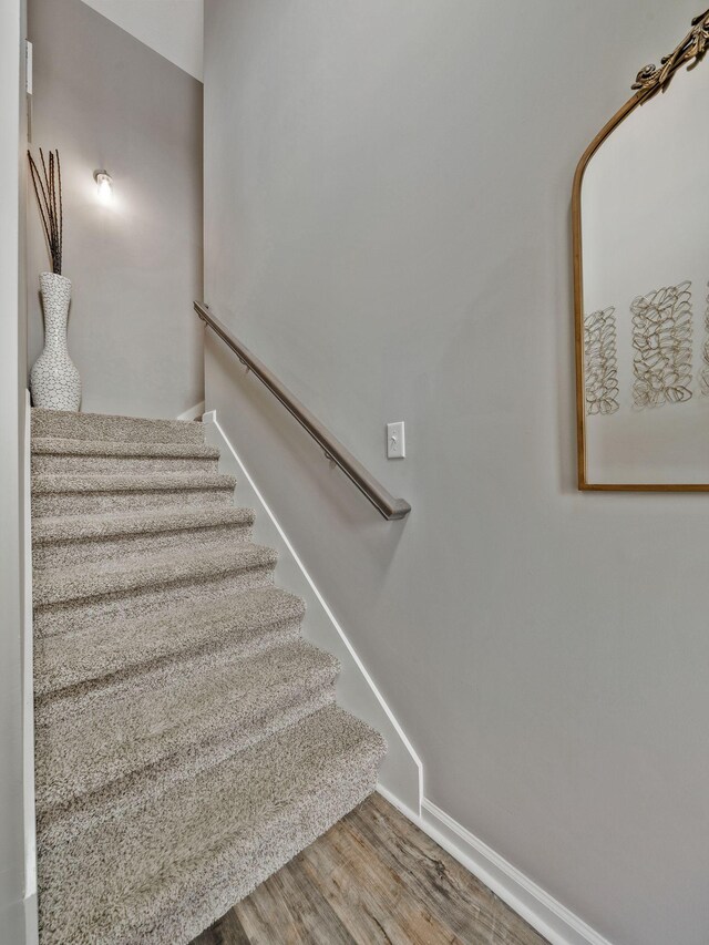 stairs featuring wood finished floors and baseboards
