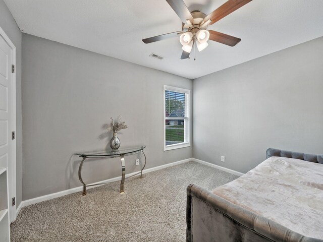 carpeted bedroom with a ceiling fan, visible vents, and baseboards