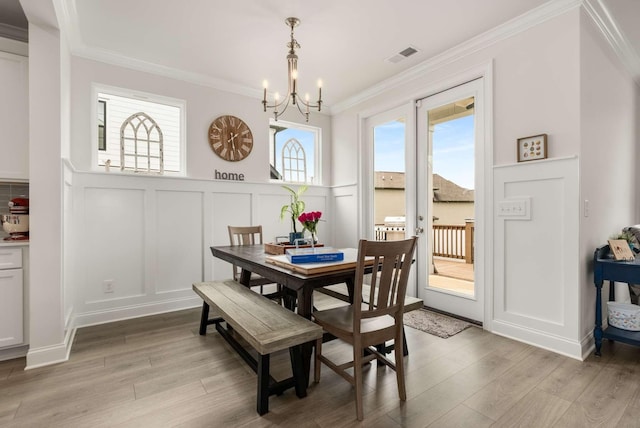 4372 Spregan Way, Smyrna, TN 37167 - dining room featuring crown molding, a wainscoted wall, light wood-type flooring, a decorative wall, and a notable chandelier