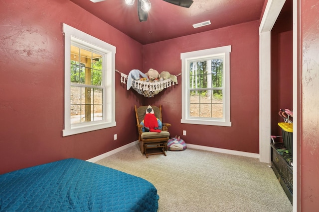 carpeted bedroom featuring a ceiling fan, visible vents, and baseboards