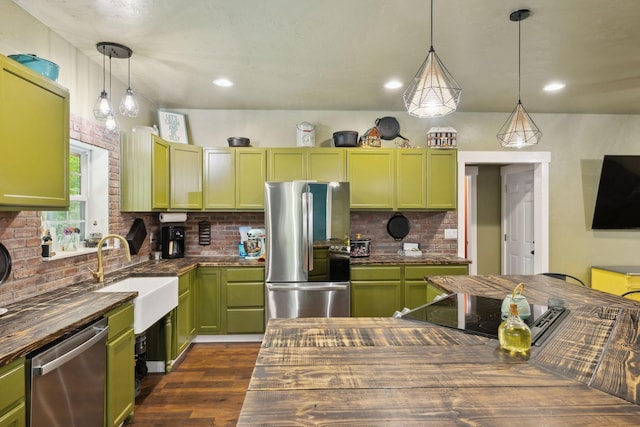 kitchen with stainless steel appliances, backsplash, butcher block counters, and green cabinets