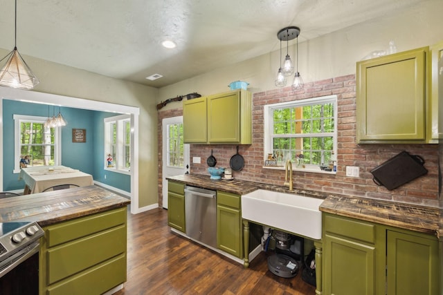 kitchen featuring appliances with stainless steel finishes, green cabinetry, wood counters, and a sink