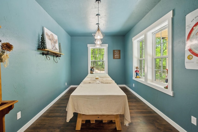 dining area featuring dark wood-style flooring and baseboards