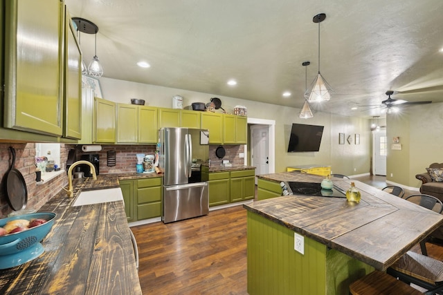 kitchen featuring green cabinets, butcher block counters, open floor plan, stainless steel fridge with ice dispenser, and backsplash