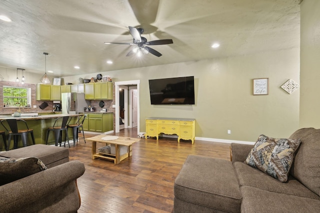 living area with a ceiling fan, recessed lighting, dark wood-style floors, and baseboards